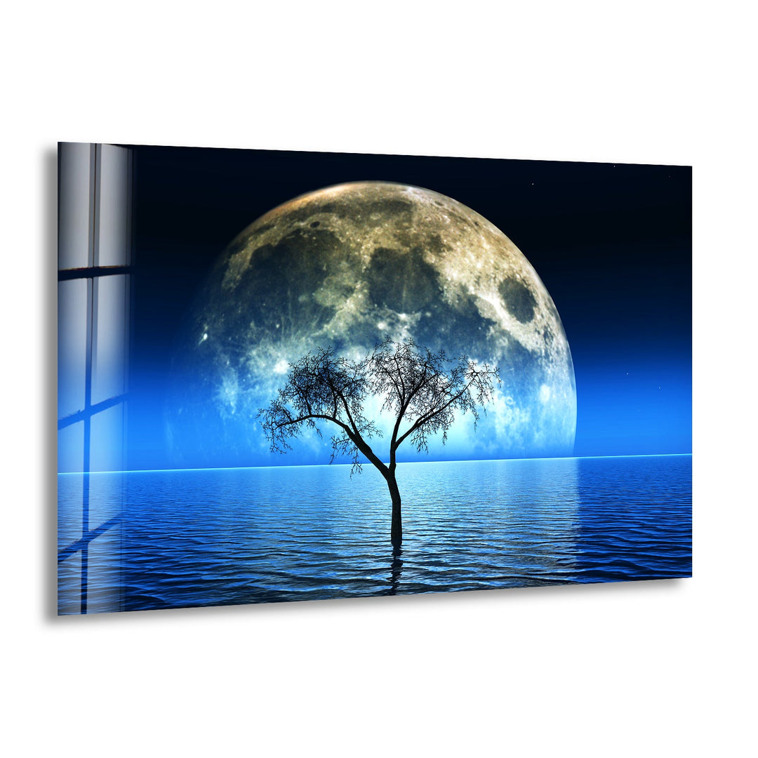 A stunning glass wall art featuring a luminous full moon rising over a tranquil water landscape.
