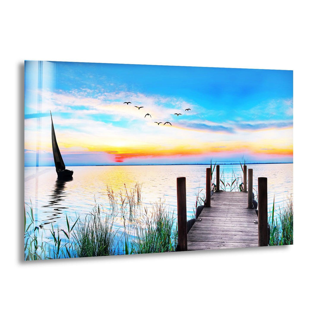 A stunning glass wall art capturing a peaceful sunset view over a calm lake.