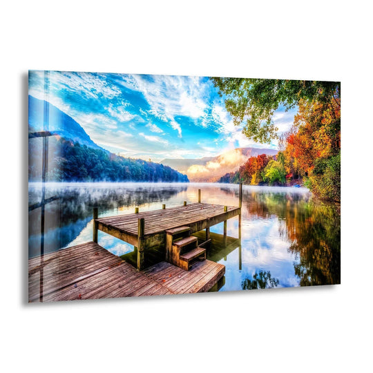 Tranquil Lake Dock Glass Wall Art capturing a peaceful wooden pier extending over a misty lake at sunrise.
