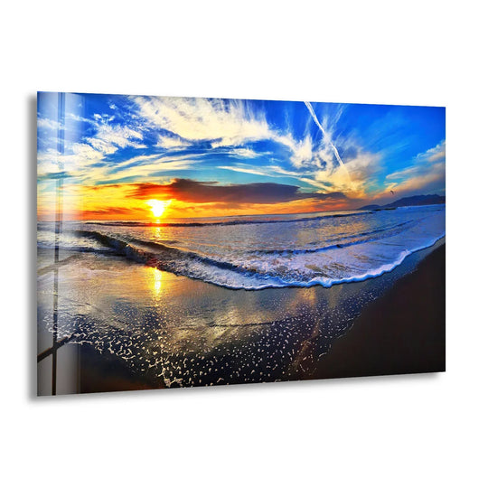 Crafted art from glass, the 'Golden Horizon Sunset Waves Glass Wall Art' showcases its high-quality, reflective surface depicting an ocean sunset.