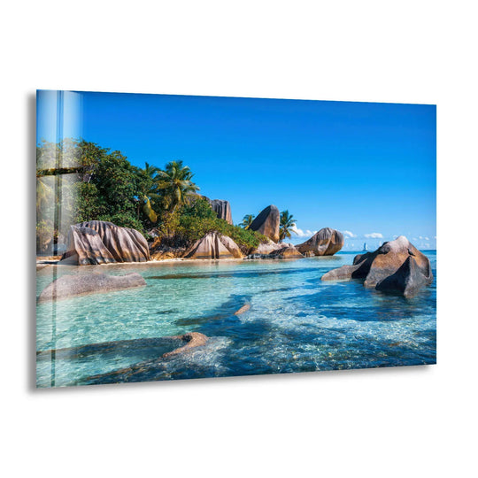 Visual rhythm is created by the repetition of rock formations against the turquoise water in this tropical rock coast glass print, a piece of unique modern wall decor.