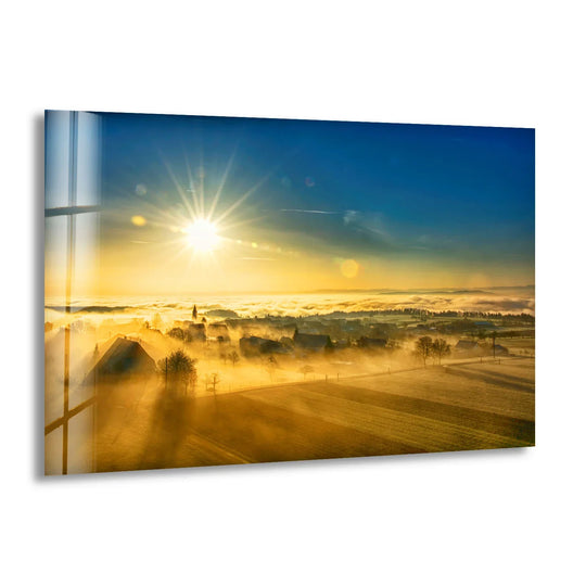 Sunlight casts striking shadows across the foggy countryside in this golden sunrise glass wall art, adding depth and warmth to your home decoration.