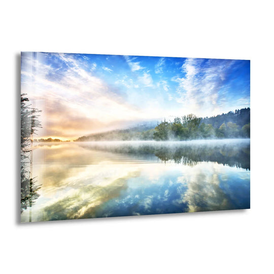 Reflecting the organic forms, the tranquil misty lake sunrise in this glass landscape print creates captivating glass wall art decor with a serene nature scene.