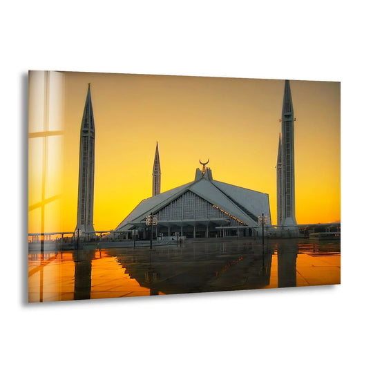 Illuminated by a dramatic sunset, the background showcases a gradient of vibrant golden hues that perfectly complements the Faisal Mosque glass wall art, making it the best glass art.
