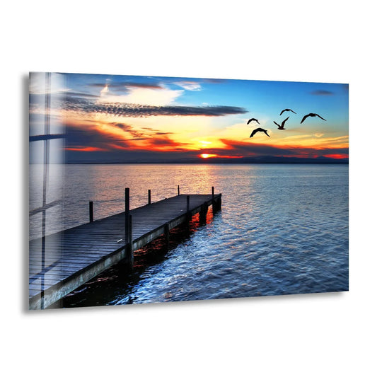 Landscape glass wall art capturing birds flocking in a sunset with ocean views and landscape art for sale