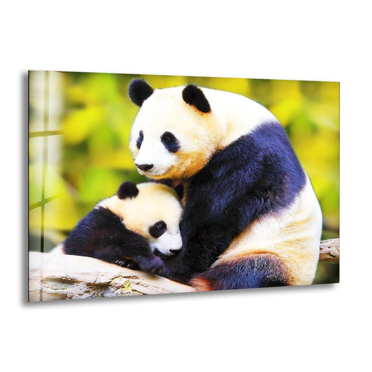 A mother and baby panda rest on a branch against a blurred green background, framed by the edge of decorative wall art.
