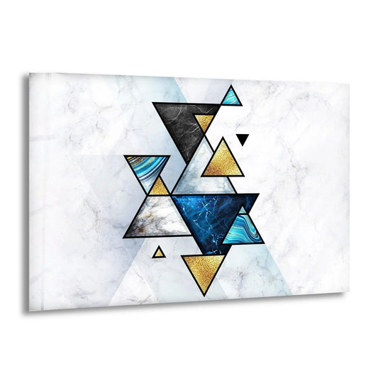 A soft marble background grounds this geometric abstract glass wall artwork with rich blue and gold triangles.