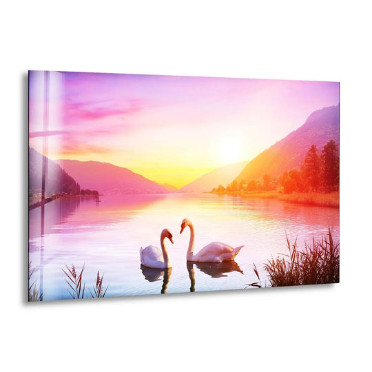 Swan Sunset glass wall art features serene romantic swans in a vivid lake and sunset landscape and it is calming decor for animal wall art lovers