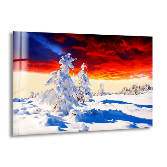 Dramatic red and blue sunset sky dominates the scene in this glass wall art prints snowy sunset landscape, making a breathtaking winter scene.