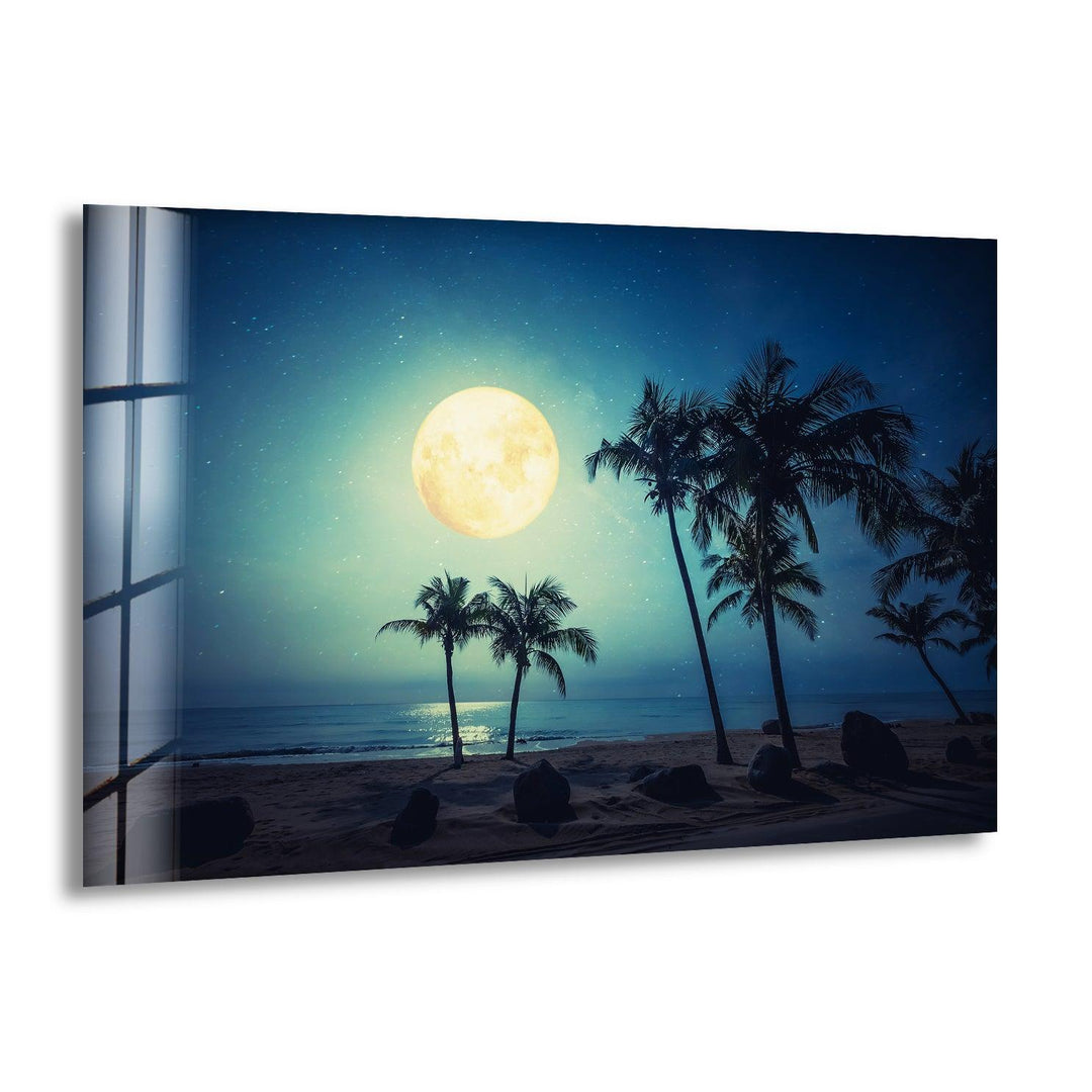 A stunning glass wall art featuring a moonlit tropical beach with palm trees and a glowing full moon.
