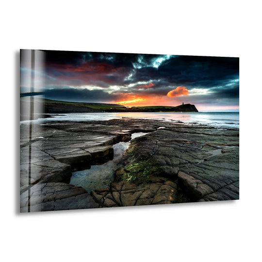 The glossy finish of this Kimmeridge Bay glass wall art enhances the dramatic coastal landscape, creating stunning wall prints with vivid color and depth.