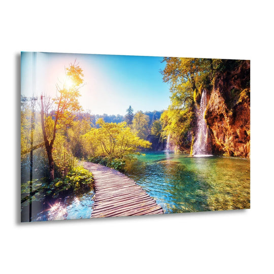 Glass wall art featuring the breathtaking Plitvice Lakes Walkway with turquoise waters and lush greenery.
