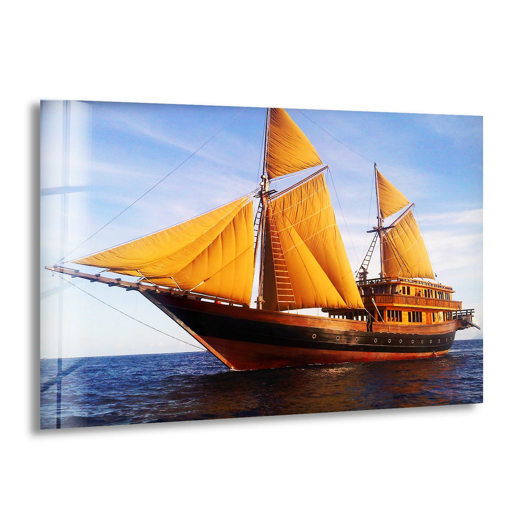 Majestic sailing ship with golden sails on the ocean at sunset, printed on glass wall art.
