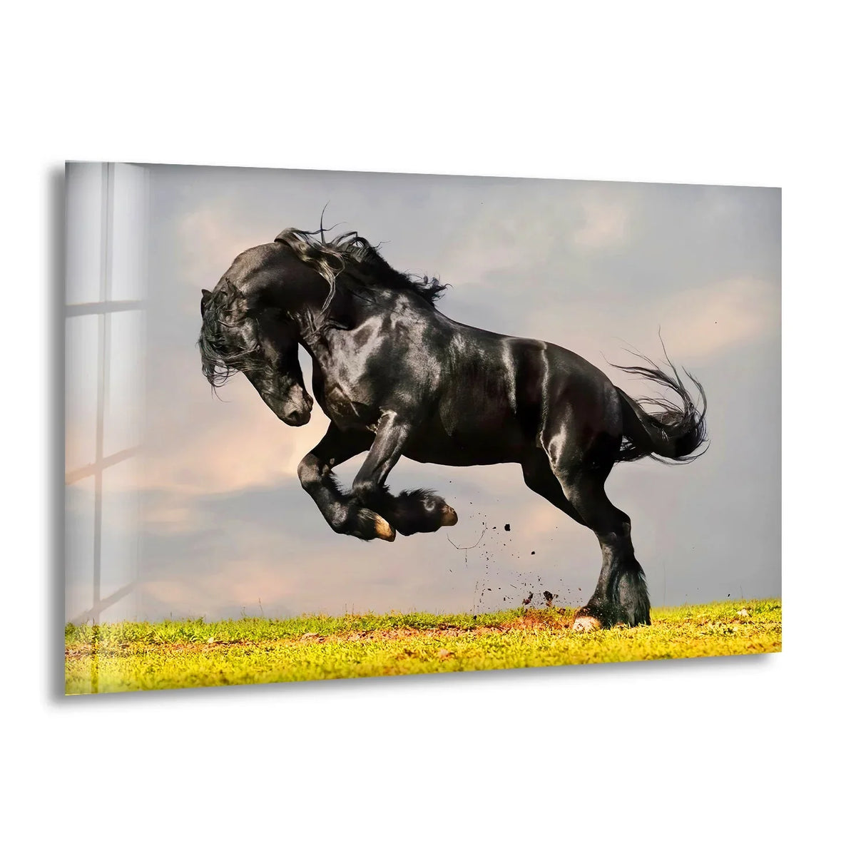 A powerful black Friesian horse leaps across a grassy field in this stunning glass art painting.