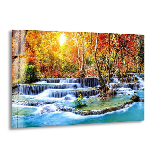 The landscape is a waterfall in autumn forest glass wall art with autumn colors and nature art perfect for a forest themed decor and wall prints