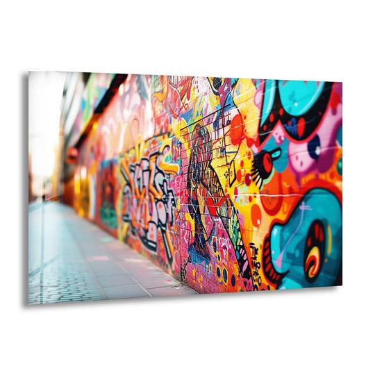 This horizontal rectangular glass wall art features a vibrant, colorful graffiti mural with bold shapes and dynamic lettering.