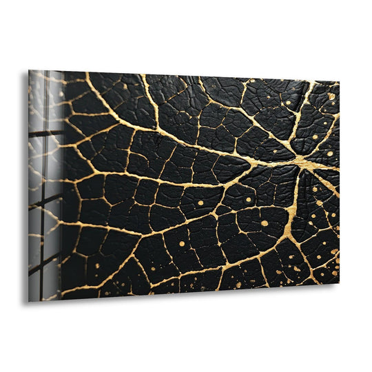 A still black and gold abstract glass art painting displays intricate, crackled veins on a dark textured surface.