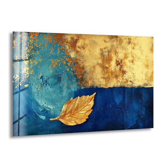 A textured navy blue background features a single, shimmering gold leaf in this stunning glass wall artwork.