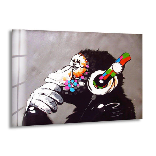A glossy glass wall print of a chimpanzee wearing colorful headphones, its face adorned with vibrant paint splatters.