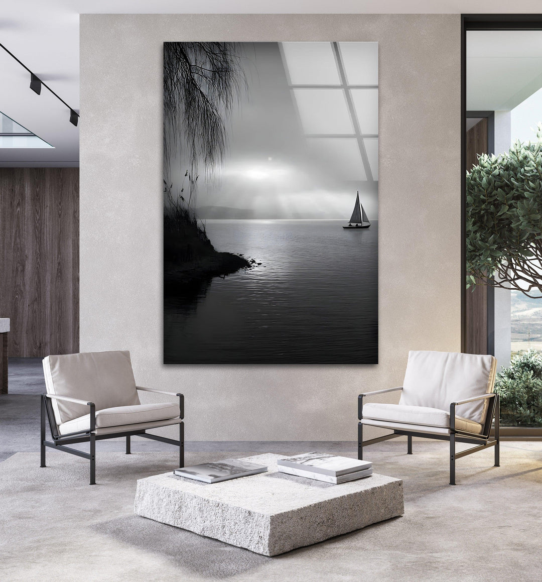 Black and white glass art depicting a quiet lakeside with a sailboat in the distance.