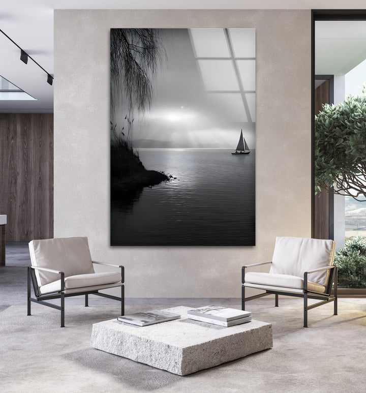 Black and white glass art depicting a quiet lakeside with a sailboat in the distance.