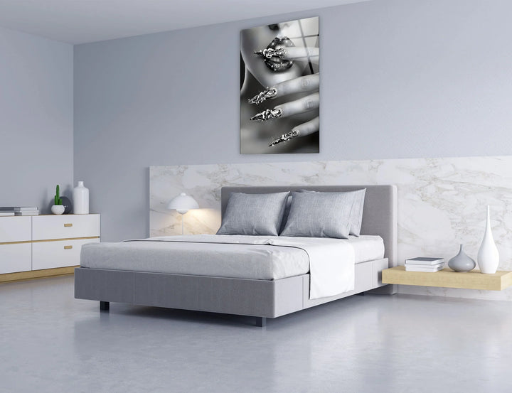 Monochrome glass art capturing a sensual close-up of sparkling lips and decorative metallic nails.