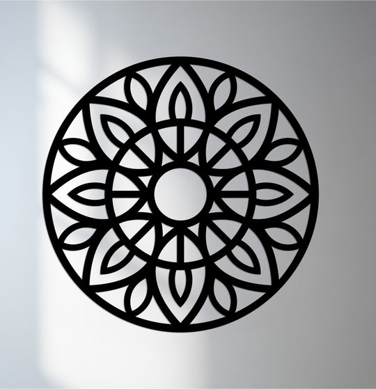 Brightest illumination highlights the open spaces of this intricate mandala design in black metal artwork, creating a play of light and shadow.