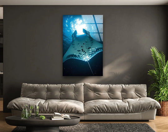 The glass wall art features a manta ray ocean animal and blue tones and creates serene ocean decor and adds oceanic colors