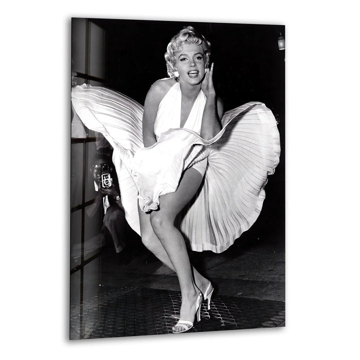 Marilyn Monroe standing over a subway grate with her white dress blowing upward.