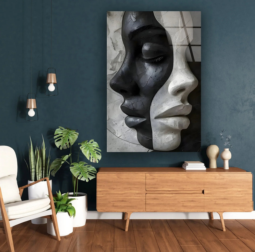Abstract dual-face design on glass highlighting contrast between light and dark feminine profiles.
