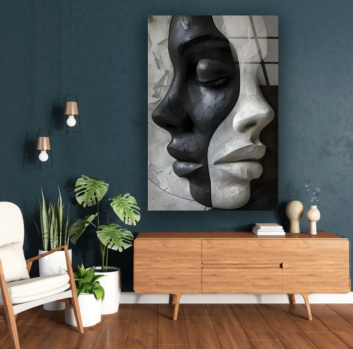 Abstract dual-face design on glass highlighting contrast between light and dark feminine profiles.