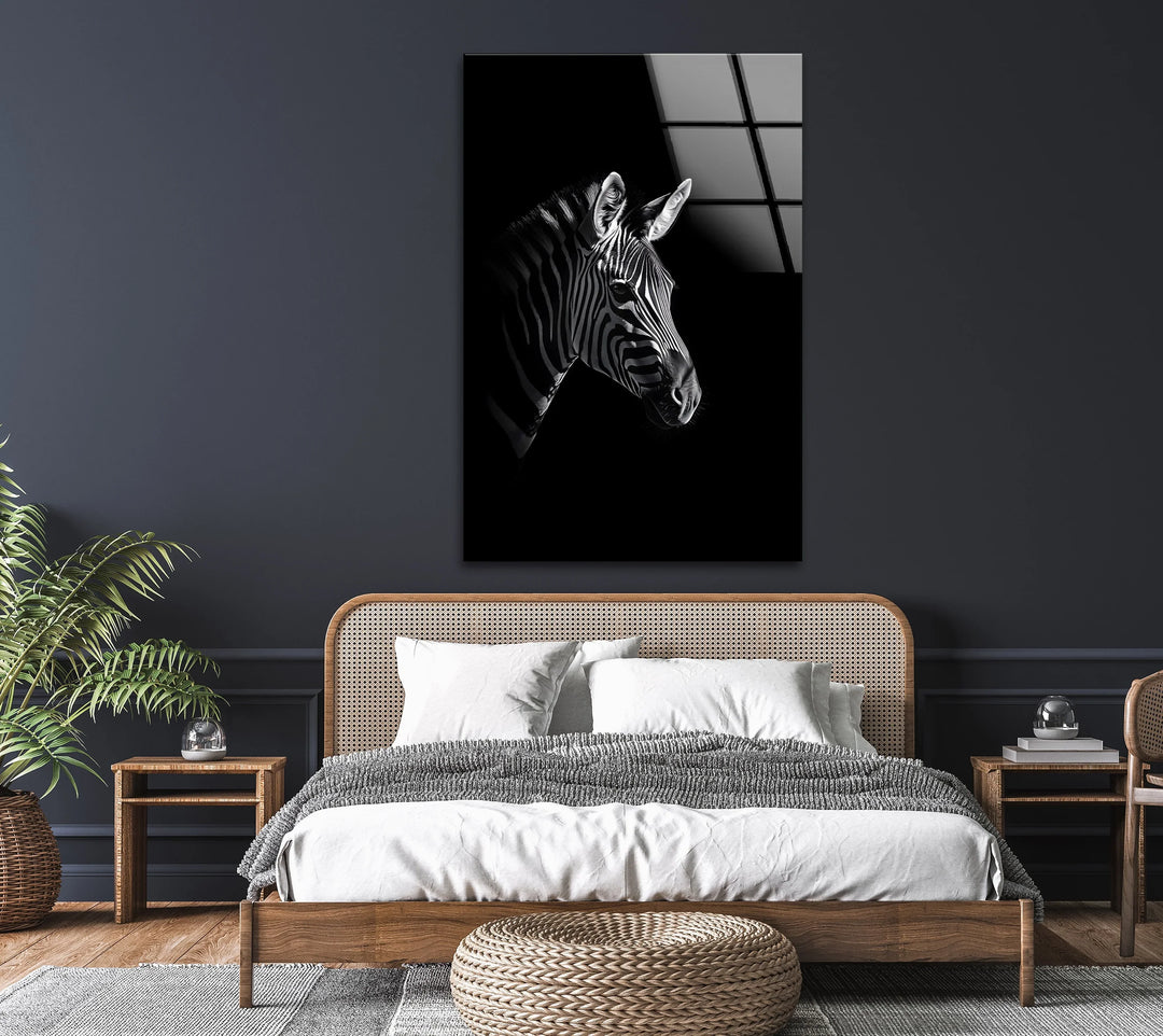 Striking zebra portrait on glass with bold contrasting stripes and shadowed background.