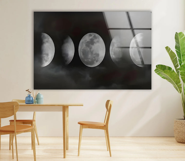 Atmospheric glass print depicting moon phases surrounded by drifting clouds in grayscale.