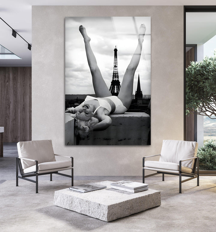 Black and white art print on glass of a woman reclining near the Eiffel Tower skyline.