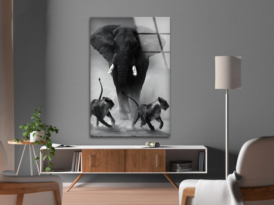 Black and white glass art capturing dynamic movement of lions escaping a charging elephant.