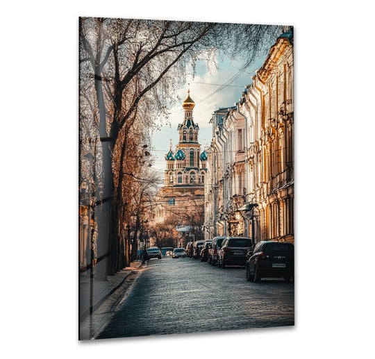 Sunlight and shadows dance across the cobblestone street and ornate buildings in this Streets of Moscow glass wall art decor, creating a striking contrast.