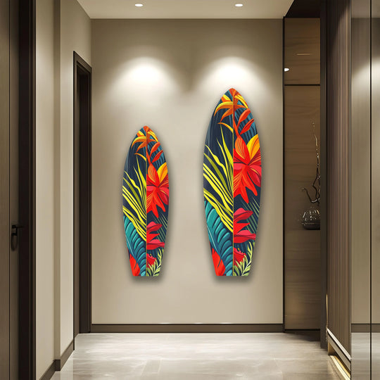 Two abstract surfboard-shaped glass wall art decor pieces feature organic botanical forms in vibrant red and green hues.