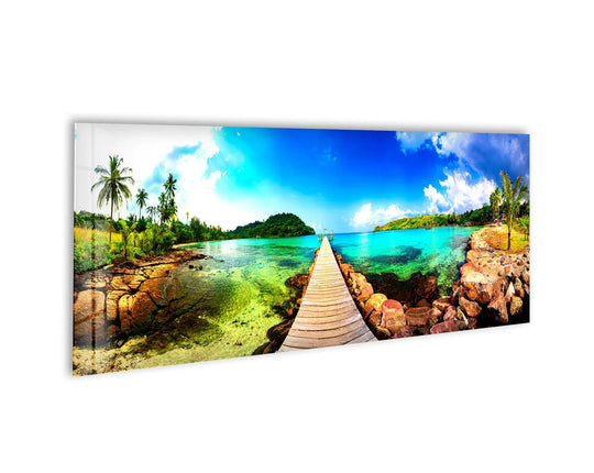 Tropical Beach With Wooden Dock glass wall art showcases a scenic coastal landscape and a wooden walkway with lush palm trees and turquoise water for large wall decor