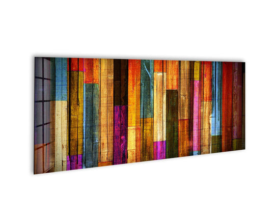 Colorful wooden glass wall art displays a vibrant abstract pattern and vertical planks with warm tones and a glossy finish above a white wall