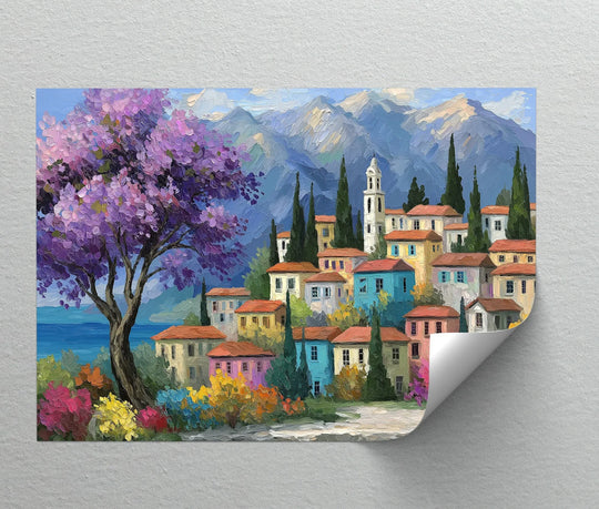 Painted in soft hues, the hanging canvas showcases a vibrant Mediterranean village canvas print with a lush purple blossom tree against mountain scenery.