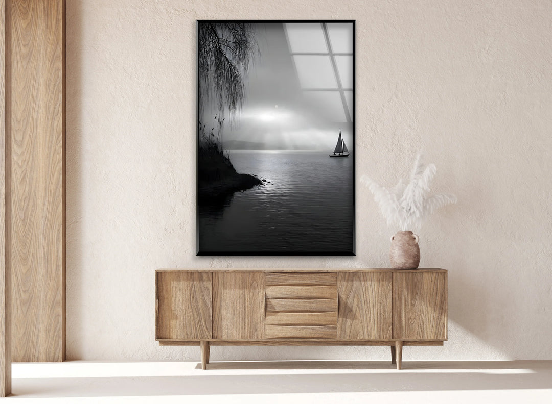 Monochrome glass art showing a lone sailboat on a serene lake with misty light.