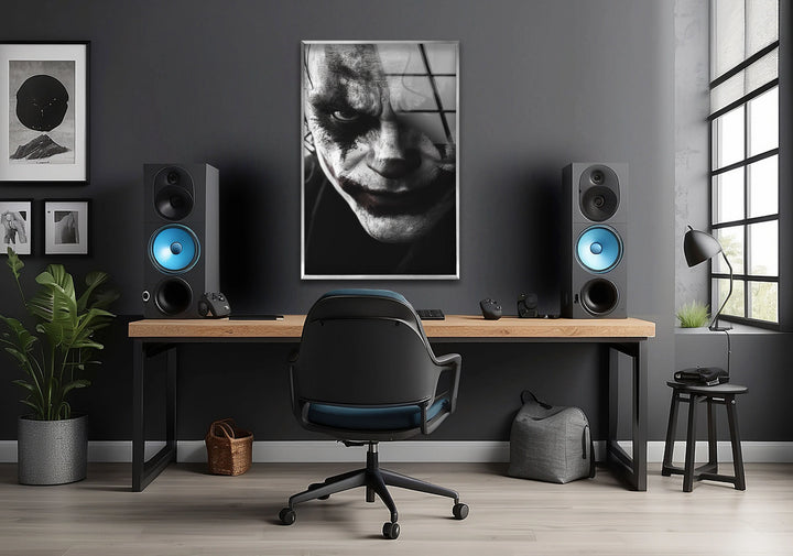 Dark-themed glass wall art highlighting a haunting clown face with strong shadows and contrast.