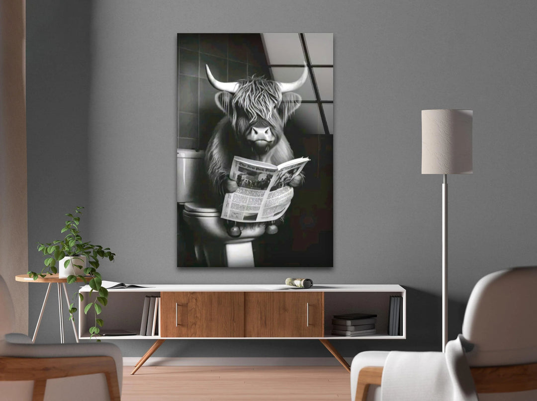 Humorous monochrome glass decor showing a cow relaxing on a toilet with a newspaper.
