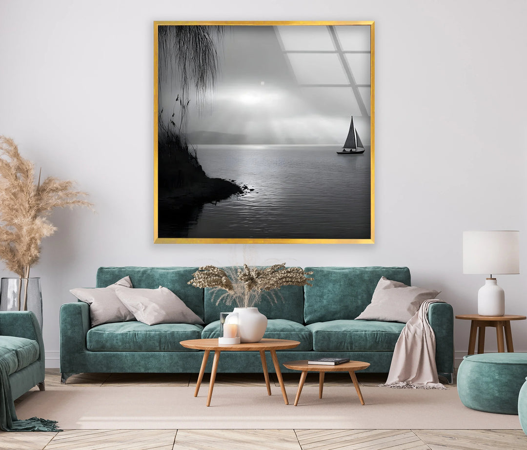 Glass wall art featuring a peaceful lake, lone sailboat, and calm black and white tones.