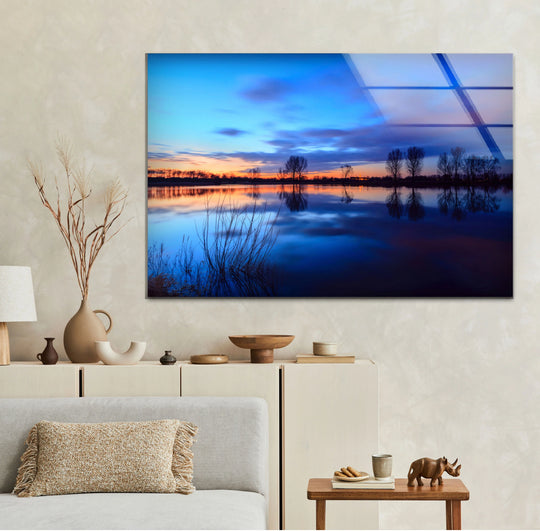 Highlighted by the frame, a blue sunset lake scene shimmers as a piece of captivating glass wall artwork, bringing a serene landscape indoors.