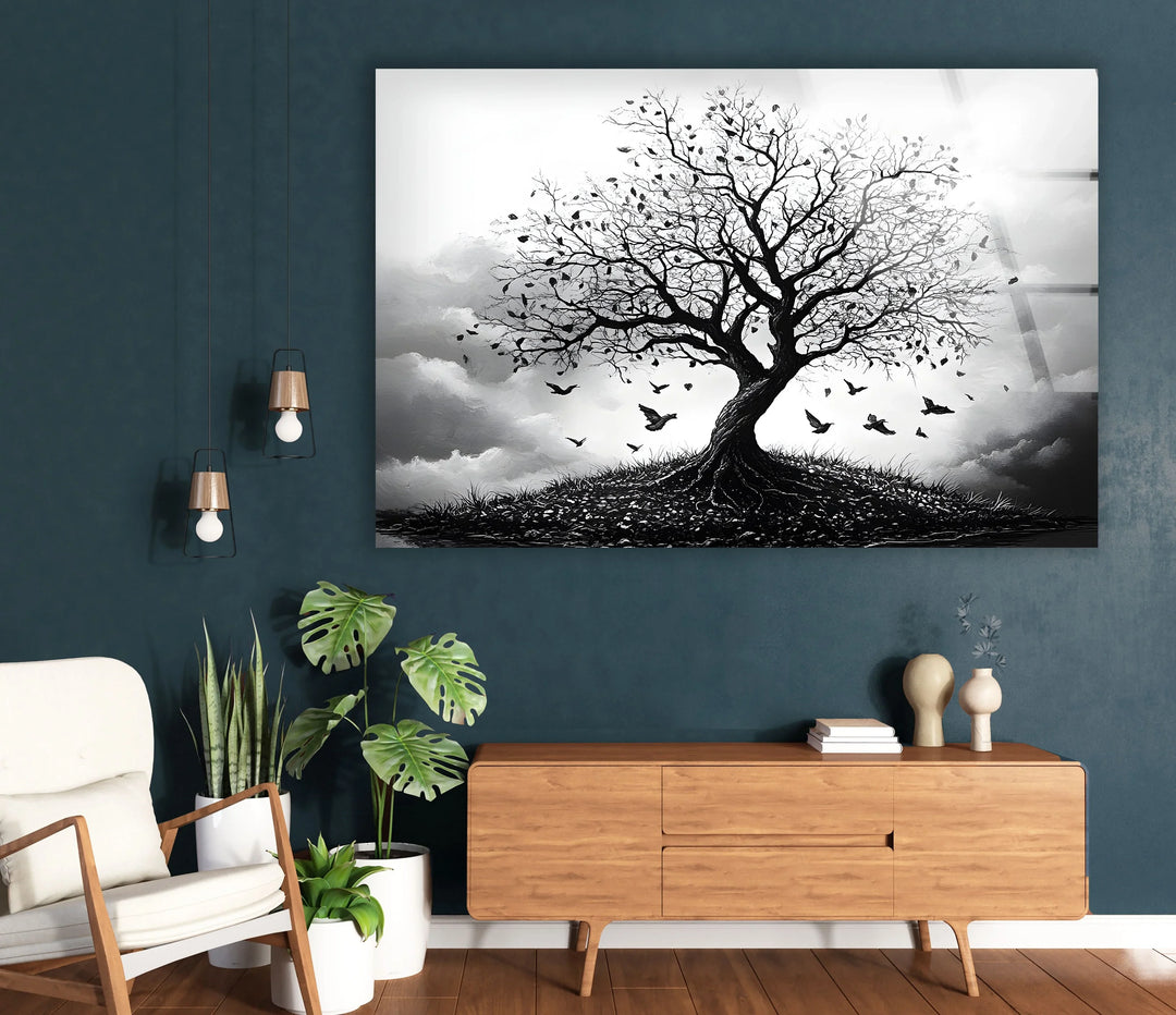 Black and white glass wall print capturing the silhouette of a tree with birds circling overhead.
