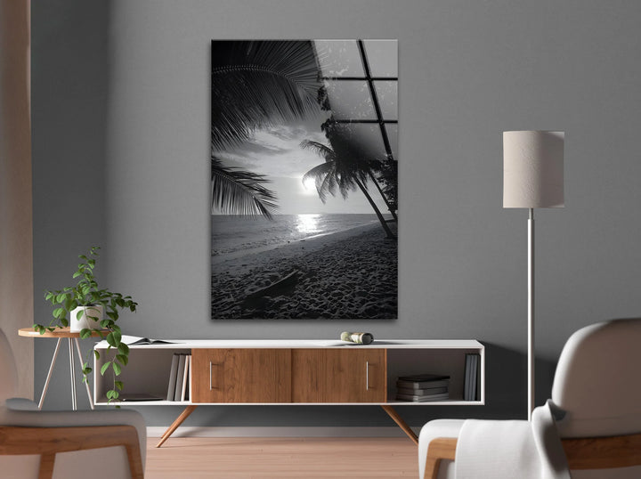 Black and white glass print of a serene beach sunset with palm silhouettes.