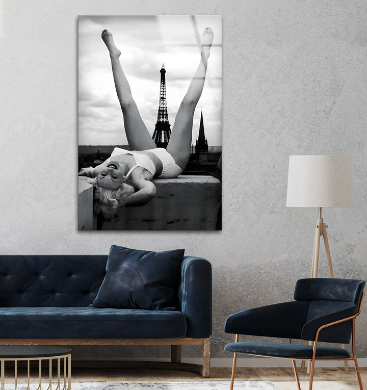 Black and white glass artwork of a woman stretching joyfully with the Eiffel Tower beyond.