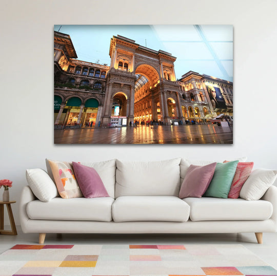 Softest light illuminates the Galleria Vittorio Emanuele II at dusk in these stunning Milan wall prints, displaying the glass wall art piece above a white sofa.