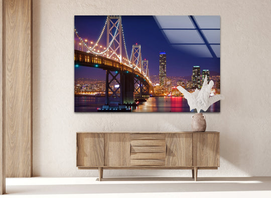 Highlighted by the organic forms of an accompanying sculptural piece, the bay bridge glass wall artwork showcases the soft light reflections of a San Francisco cityscape at night.